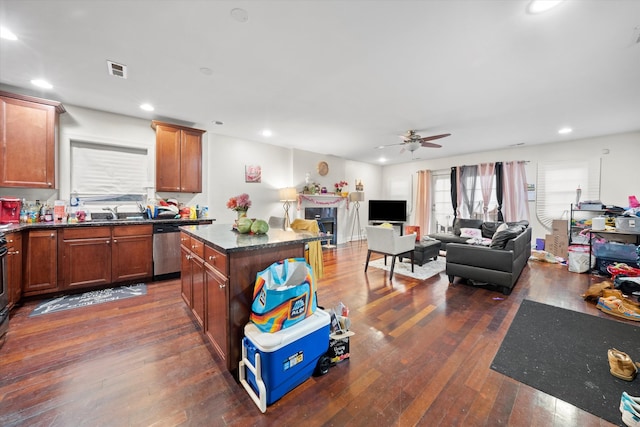 kitchen with stainless steel dishwasher, ceiling fan, sink, a center island, and dark hardwood / wood-style floors