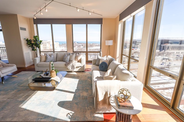 living area featuring visible vents and wood finished floors