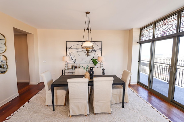 dining space with a wall of windows, wood finished floors, and baseboards