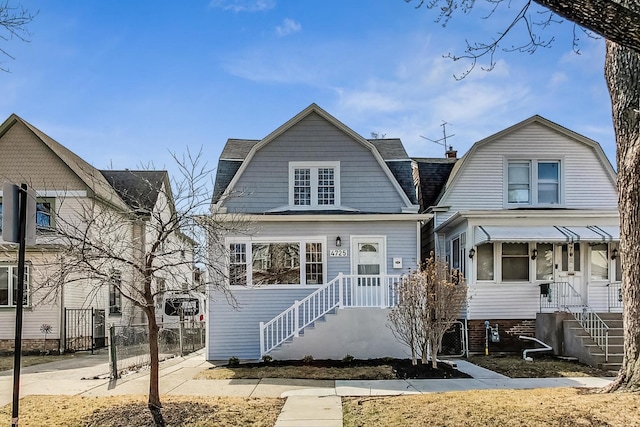 view of front of home featuring fence and a gambrel roof