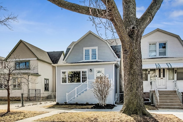 view of front of house featuring a gambrel roof and fence