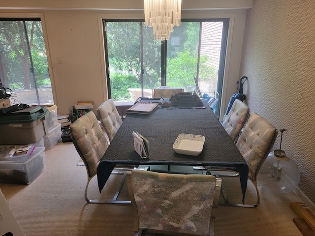 dining area featuring carpet and an inviting chandelier