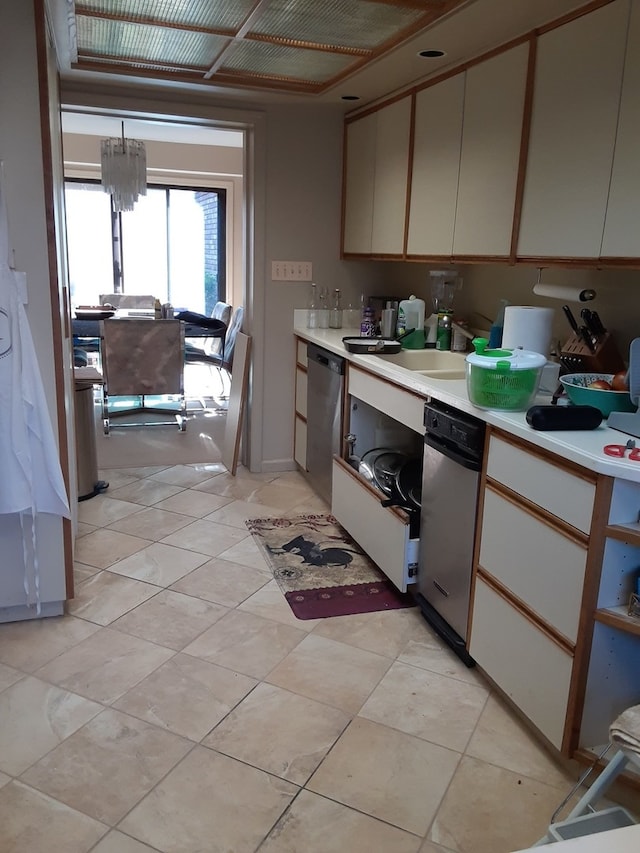 kitchen with stainless steel dishwasher, light tile patterned floors, and sink