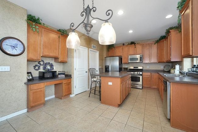 kitchen with a kitchen bar, decorative light fixtures, a center island, light tile patterned floors, and appliances with stainless steel finishes