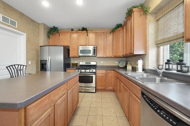 kitchen featuring stainless steel appliances, light tile patterned flooring, and sink