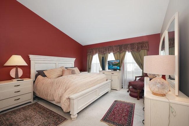 carpeted bedroom featuring vaulted ceiling