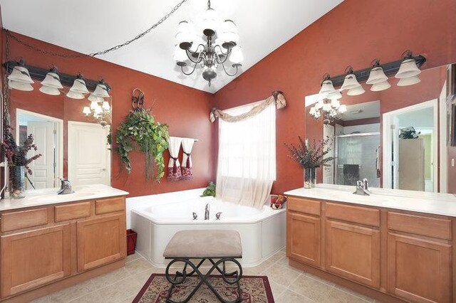 bathroom featuring an inviting chandelier, lofted ceiling, vanity, and separate shower and tub