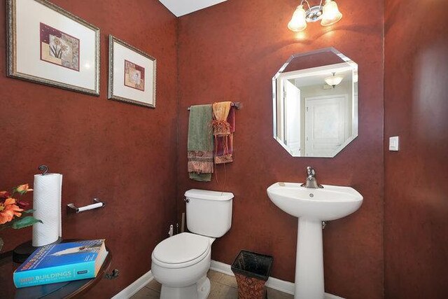 bathroom featuring sink, tile patterned floors, a chandelier, and toilet