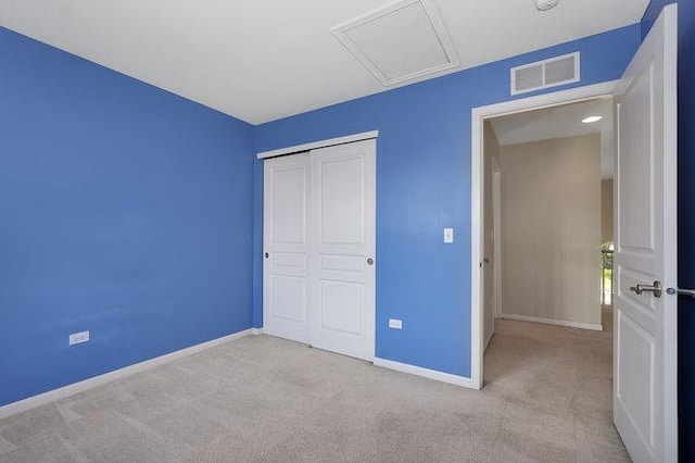 unfurnished bedroom featuring light colored carpet and a closet