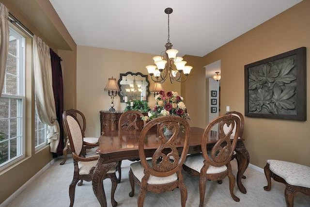 dining space with a healthy amount of sunlight, light carpet, and a chandelier