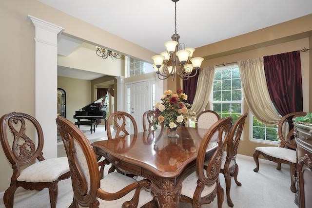 carpeted dining space featuring decorative columns and a notable chandelier