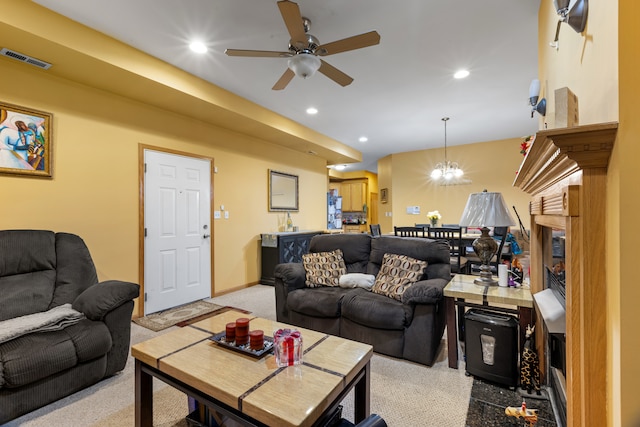 carpeted living room with ceiling fan with notable chandelier