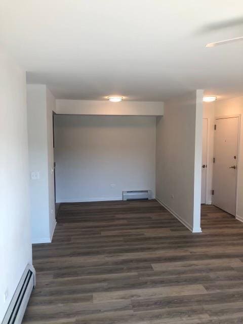 empty room featuring a baseboard radiator and dark wood-type flooring