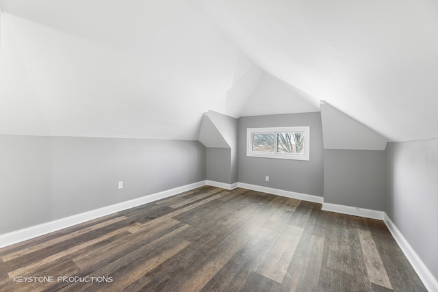 additional living space with hardwood / wood-style flooring and lofted ceiling