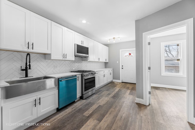 kitchen featuring stainless steel appliances, dark hardwood / wood-style flooring, white cabinets, backsplash, and sink