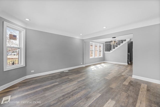 unfurnished living room with wood-type flooring and a healthy amount of sunlight