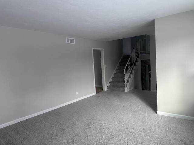 carpeted spare room with a fireplace