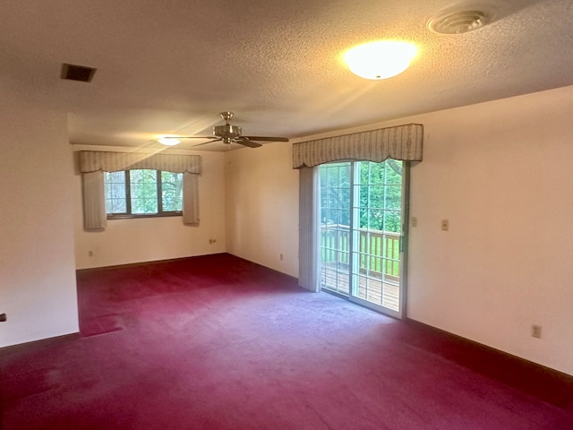 empty room featuring ceiling fan, a textured ceiling, and carpet floors