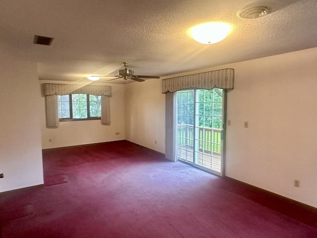 spare room featuring carpet flooring, a ceiling fan, a textured ceiling, and visible vents