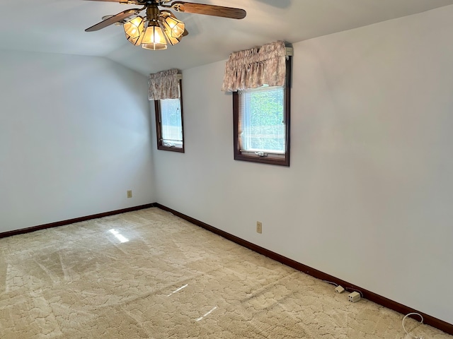 carpeted spare room with vaulted ceiling and ceiling fan