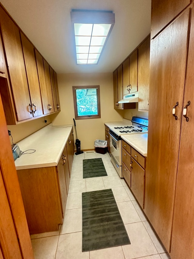 kitchen with light tile patterned floors and white gas range oven