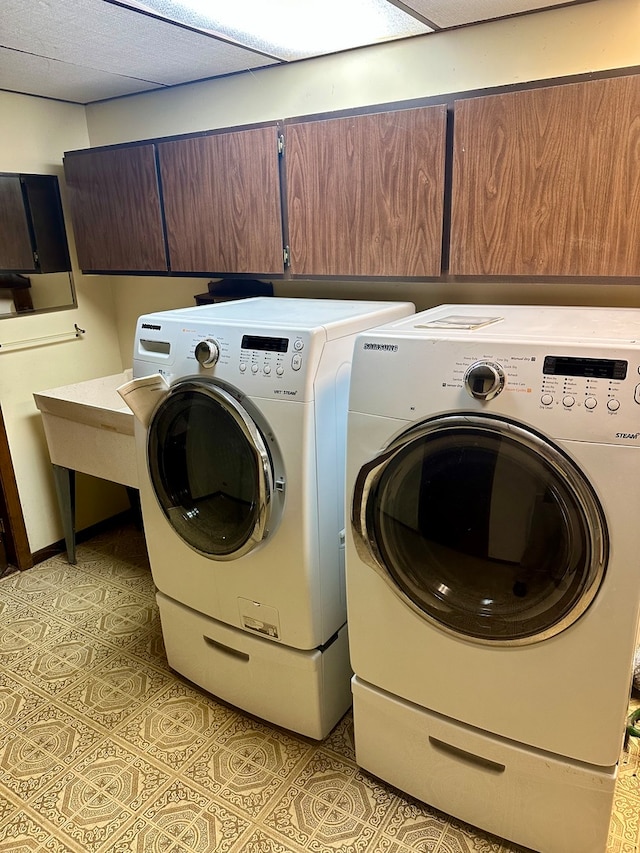 washroom with cabinets, light tile patterned floors, and washer and dryer