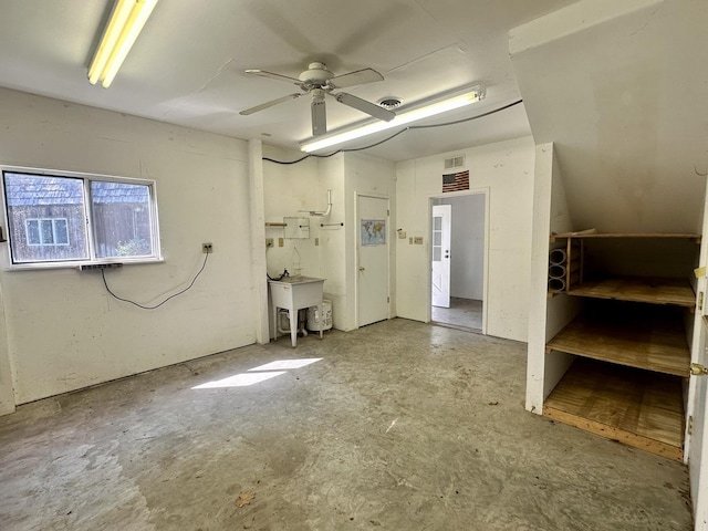 spare room with unfinished concrete floors, a sink, visible vents, and ceiling fan