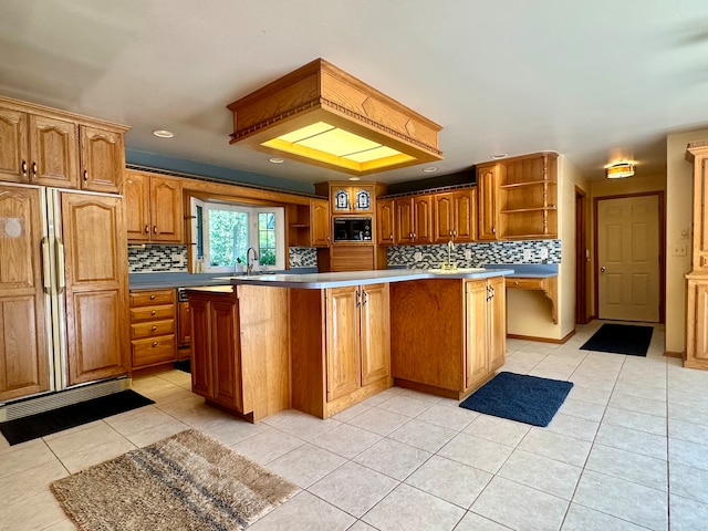 kitchen featuring tasteful backsplash, built in appliances, a kitchen island, and light tile patterned floors