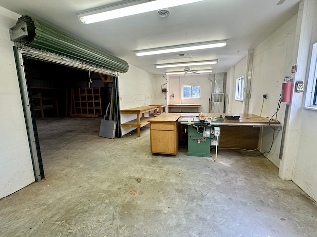 misc room with concrete floors, a workshop area, and ceiling fan