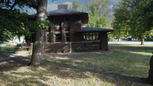 328 E Mulberry St, Watseka, IL 60970 - rear view of property with brick siding, a lawn, and a chimney