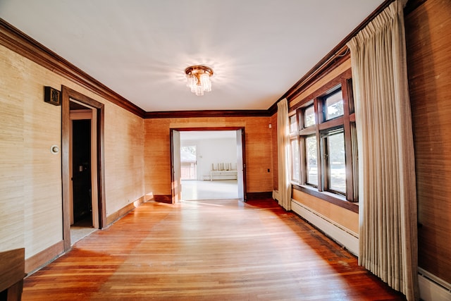 hall featuring ornamental molding, hardwood / wood-style flooring, and a baseboard heating unit