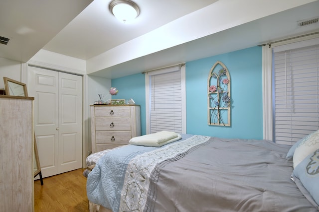 bedroom with light hardwood / wood-style flooring and a closet