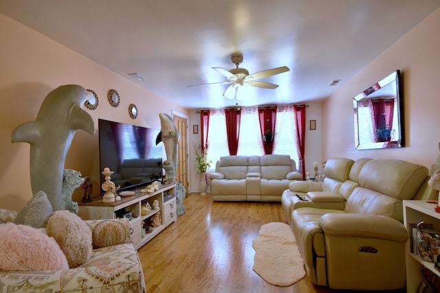 living room featuring ceiling fan and light hardwood / wood-style floors