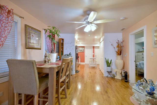 dining space with ceiling fan and light hardwood / wood-style floors