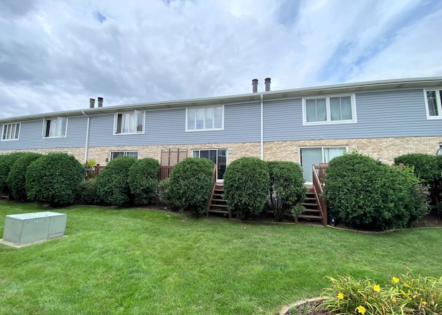 rear view of property with a lawn