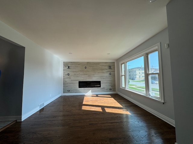 unfurnished living room with dark wood-style floors, baseboards, a fireplace, and visible vents