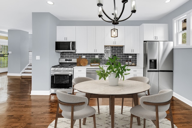 kitchen featuring appliances with stainless steel finishes, dark hardwood / wood-style floors, backsplash, and white cabinets