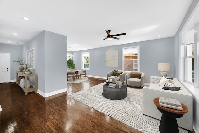 living room with ceiling fan with notable chandelier and wood-type flooring