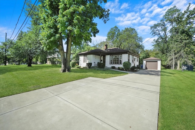 ranch-style house with a garage, a front lawn, and an outbuilding