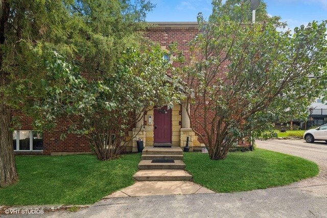 obstructed view of property featuring a front lawn