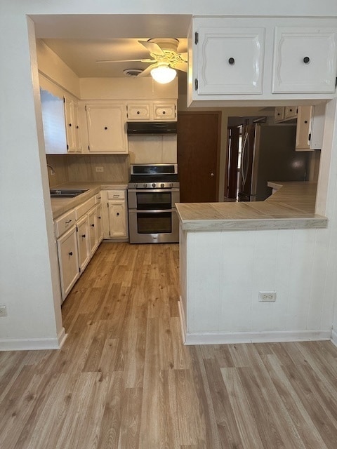 kitchen featuring ceiling fan, white cabinetry, stove, and kitchen peninsula