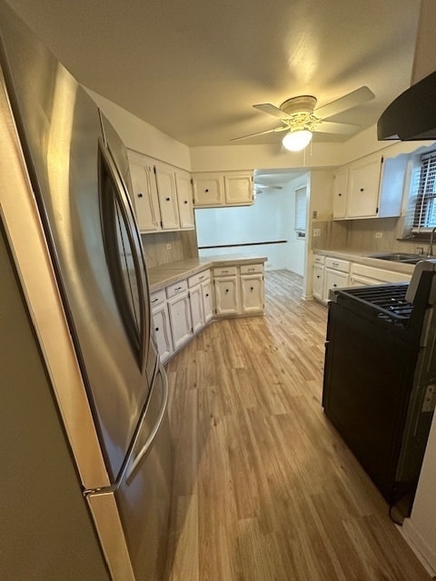 kitchen featuring light wood-type flooring, white cabinets, decorative backsplash, and stainless steel fridge