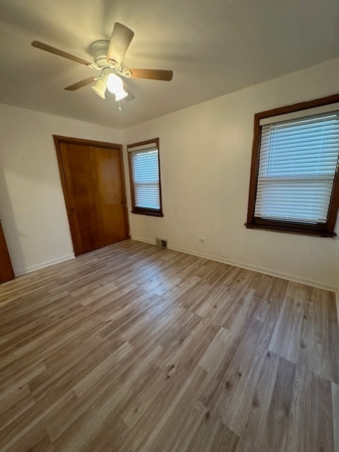 unfurnished bedroom featuring ceiling fan, hardwood / wood-style flooring, and a closet