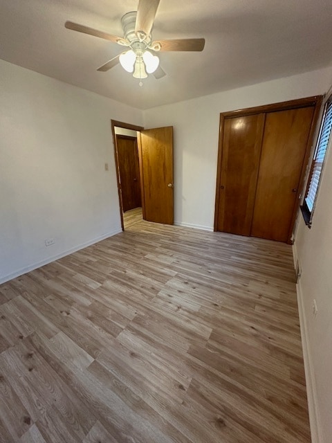 unfurnished bedroom with ceiling fan, a closet, and light hardwood / wood-style floors