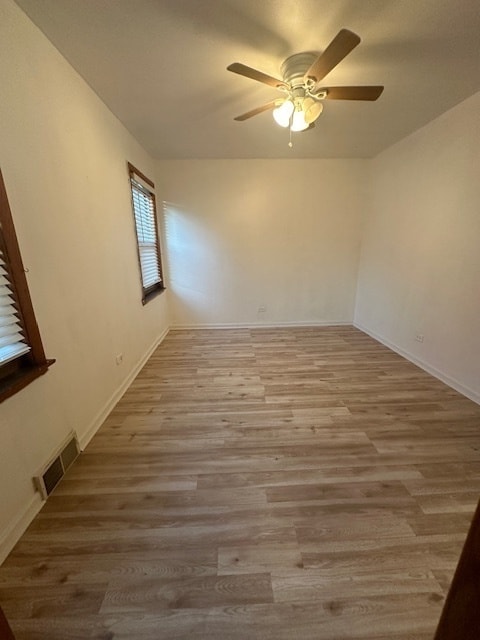 empty room with ceiling fan and light hardwood / wood-style flooring