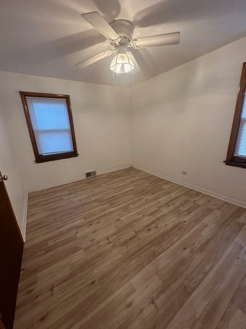 empty room with hardwood / wood-style floors and ceiling fan