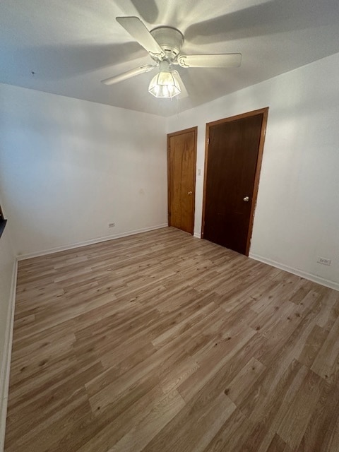 unfurnished bedroom with ceiling fan and hardwood / wood-style flooring