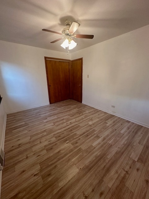 unfurnished bedroom featuring hardwood / wood-style floors and ceiling fan