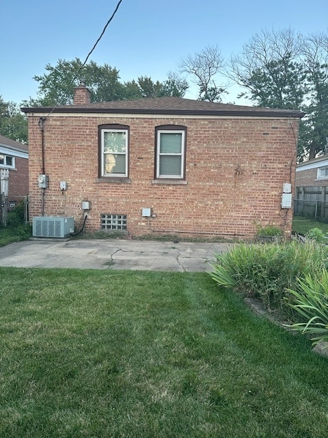 back of property featuring cooling unit and a lawn