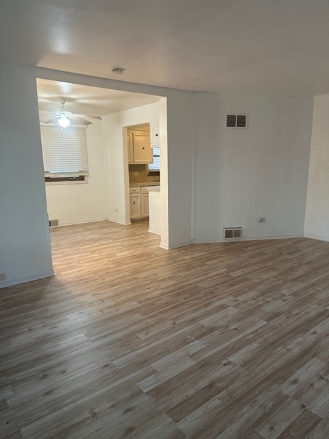 unfurnished living room featuring ceiling fan and hardwood / wood-style flooring